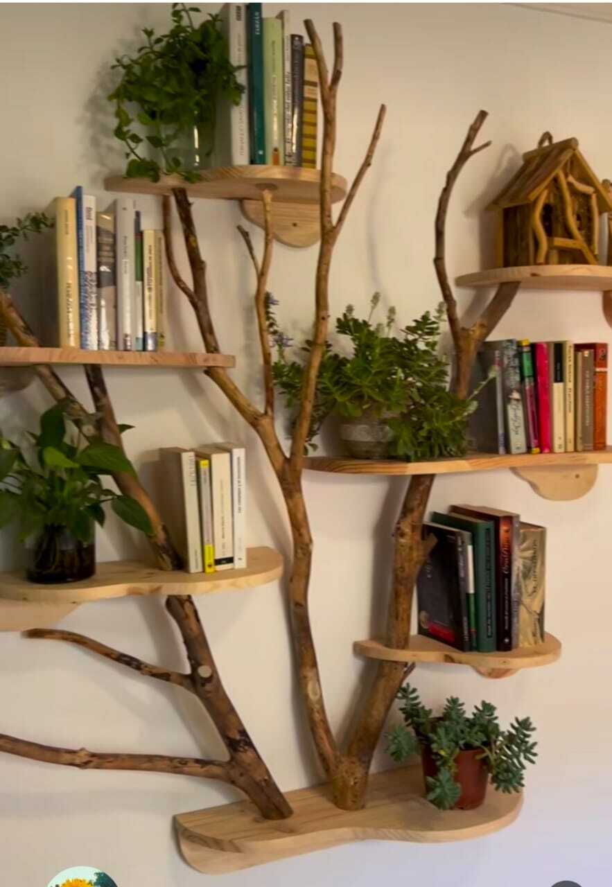 Wooden tree-branch shelf with books, plants, and birdhouse decor